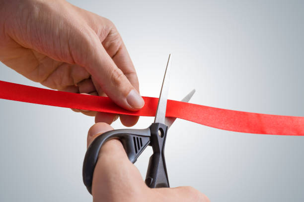 istock Man hands are cutting red ribbon with scissors. Opening event. 842772252
