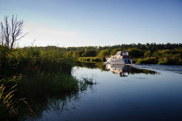 Demmin, Germany - 08/15/2017: A motorboat cruising on Peene river near Demmin in Mecklenburg - Western Pomerania.