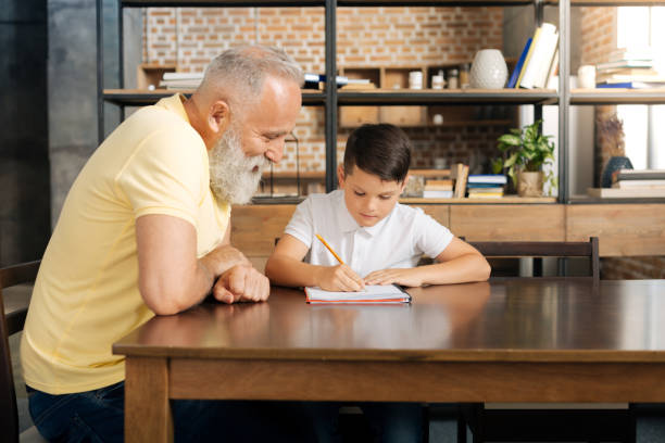 istock Loving grandfather watching his grandson do sums 842773250
