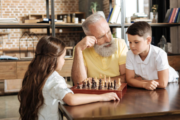 istock Grandfather giving his grandson a tip in chess game 842780272