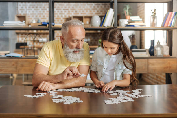 istock Grandfather and granddaughter being immersed into doing jigsaw puzzle 842781442