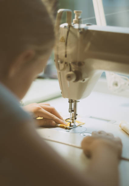 istock Little girl working on sewing machine at home. Close-up view. 842782586