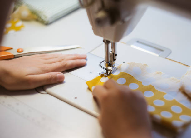 istock Little girl working on sewing machine at home. Close-up view. 842782610