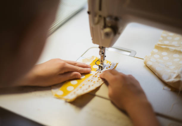 istock Little girl working on sewing machine at home. Close-up view. 842782626