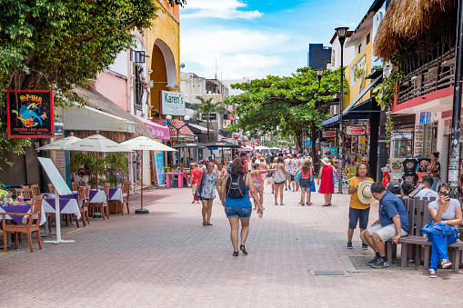 People walking along the 5th Avenue in Playa del Carmen during a summer day. The street is the shopping and restaurant centre in downtown of the city.
