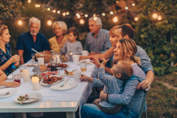 Thanksgiving with family Photo of a big family during Thanksgiving dinner, celebrating holiday together in the backyard party social event stock pictures, royalty-free photos & images