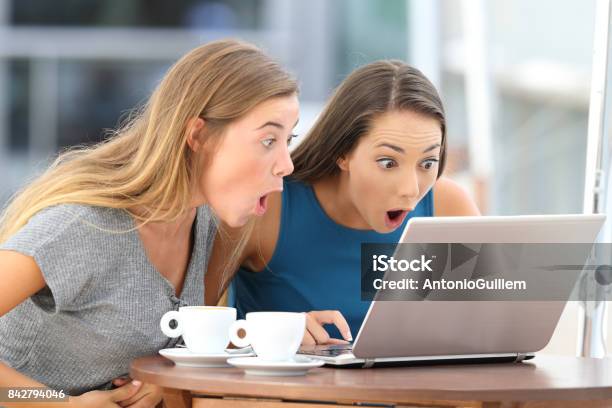 Amazed Friends Watching Scandalous Content In A Bar Stock Photo - Download Image Now