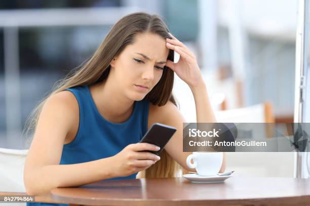 Worried Woman Holding Phone And Waiting For A Call Stock Photo - Download Image Now - Suspicion, Mobile Phone, One Person