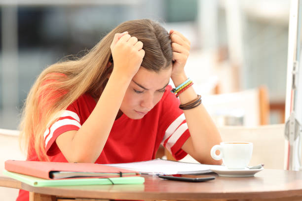 sfrustrowany uczeń próbuje zrozumieć notatki w barze - reading early teens teenager adolescence zdjęcia i obrazy z banku zdjęć