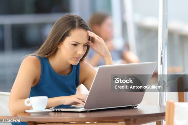 Worried Executive Reading On Line Content In A Bar Stock Photo - Download Image Now - Adversity, Internet, Laptop