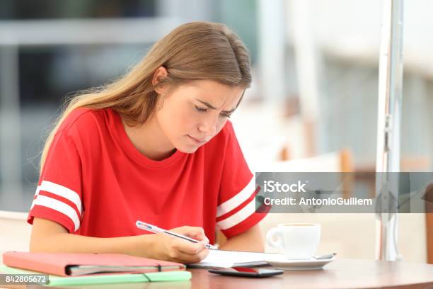 Confused Student Studying In A Coffee Shop Stock Photo - Download Image Now - Adversity, Reading, Studying