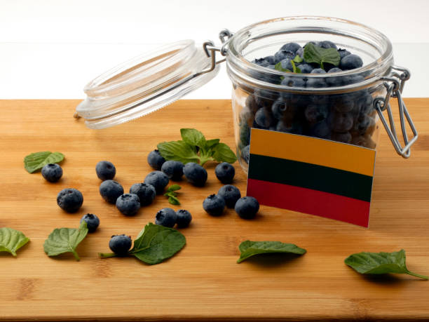 istock Lithuanian flag on a wooden plank with blueberries isolated on white 842817546