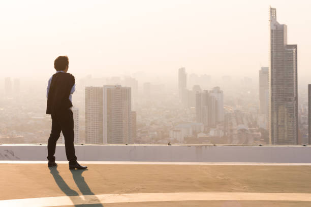 istock Businessman is looking at city on rooftop 842817964