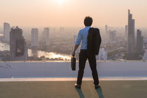 istock Businessman is looking at city on rooftop 842820238