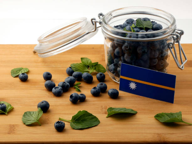 istock Nauru flag on a wooden plank with blueberries isolated on white 842820866