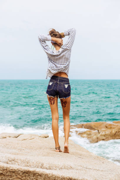 istock Pretty girl on big stone at the beach. 842821192