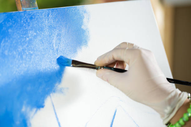 istock artist's hand with brush painting on canvas 842822322