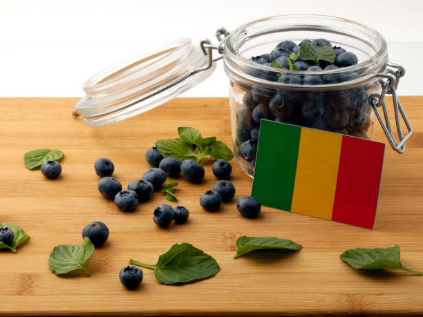 istock Malian flag on a wooden plank with blueberries isolated on white 842822634