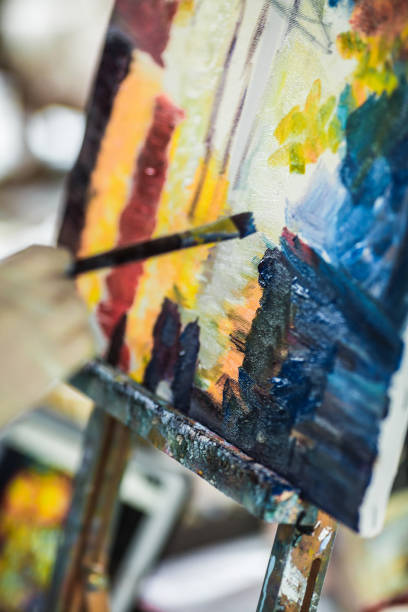 istock artist's hand with brush painting on canvas 842825564