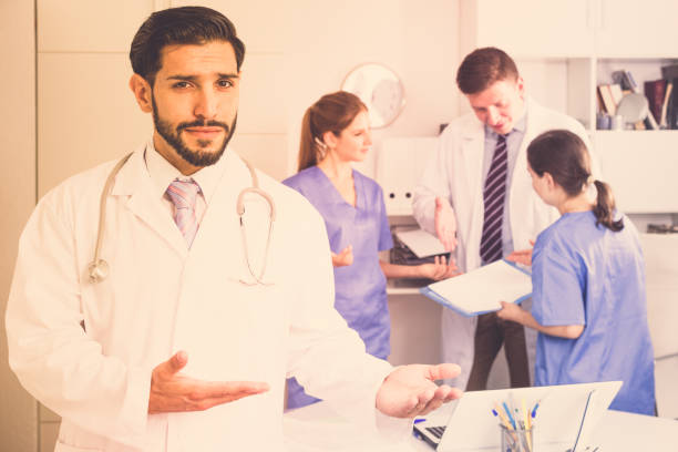istock Bearded doctor inviting in medical office 842825766