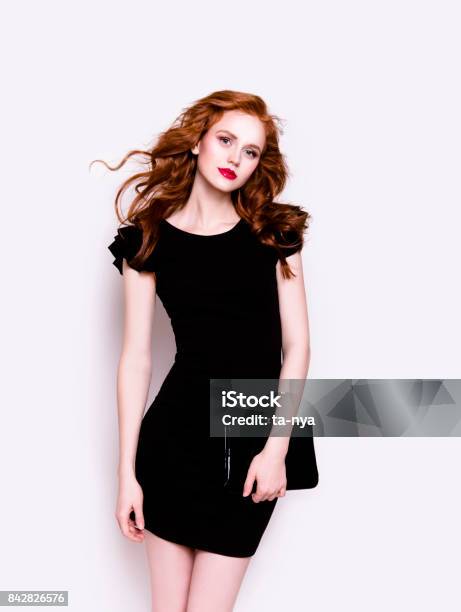 Beautiful Young Woman In Luxury Black Cocktail Dress Holding Clutch Stock Photo - Download Image Now