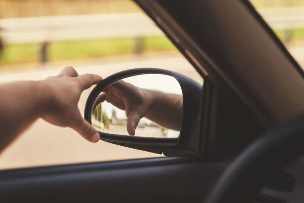 istock man's hand corrects the side mirror in the car, retro toning 842829448