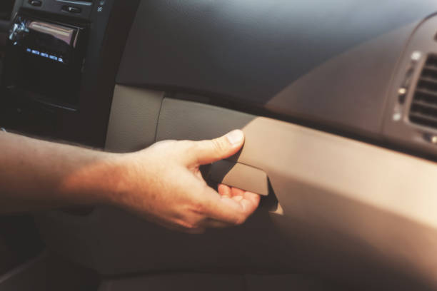 Male hand opens the glove compartment in the car, retro toning stock photo
