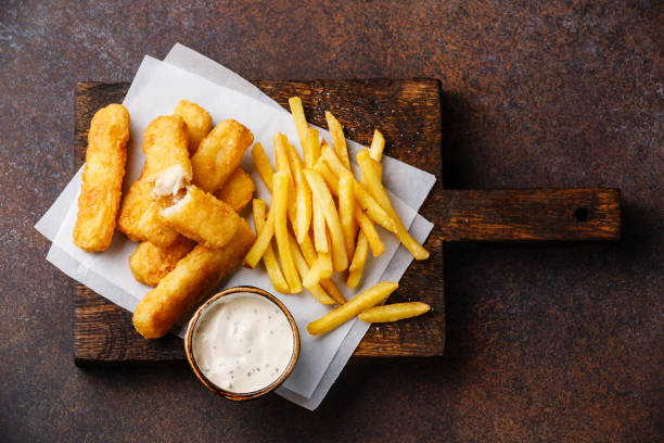 Fish fingers and Chips with tartar sauce Fish fingers and Chips british fast food with tartar sauce on dark background fish stick stock pictures, royalty-free photos & images