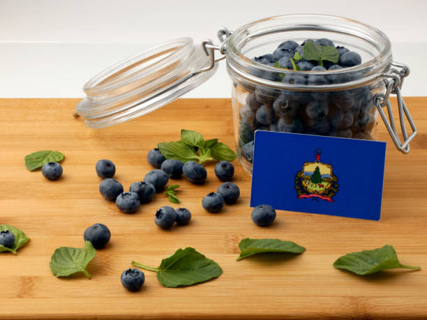 istock Vermont flag on a wooden plank with blueberries isolated on white 842832630