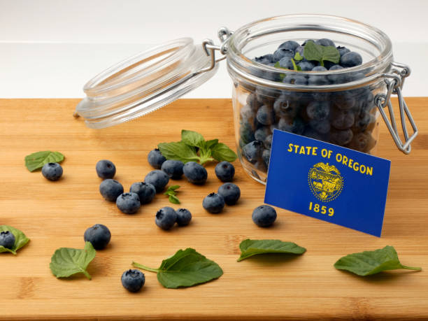 Oregon flag on a wooden plank with blueberries isolated on white