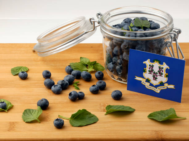 istock Connecticut flag on a wooden plank with blueberries isolated on white 842832942