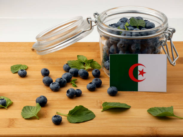 istock Algerian flag on a wooden plank with blueberries isolated on white 842833684