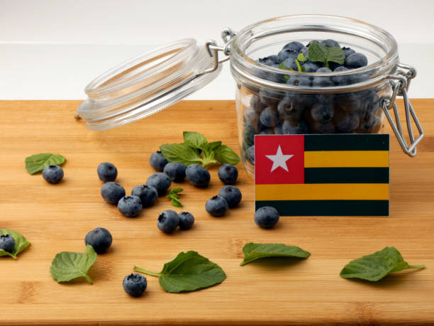 istock Togolese flag on a wooden plank with blueberries isolated on white 842836162