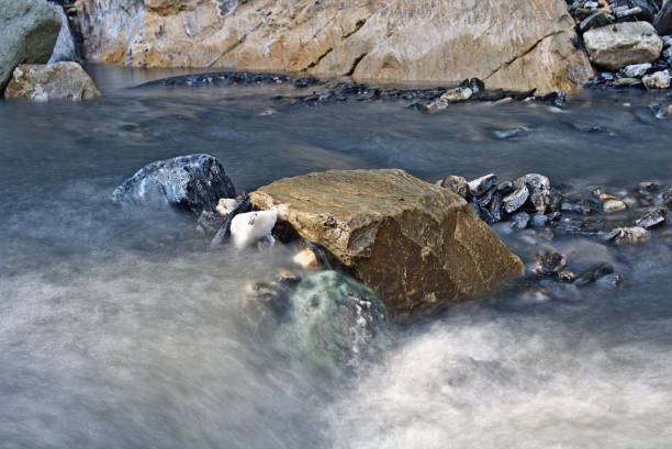 istock Boulders in a small mountain stream surrounded by smooth flowing water (long time exposure) 842840072