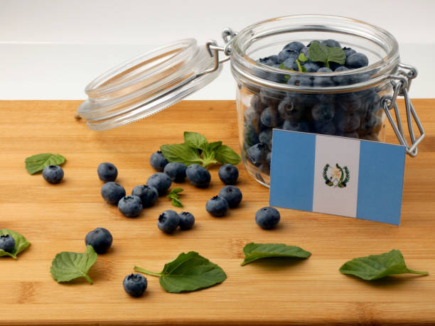 istock Guatemalan flag on a wooden plank with blueberries isolated on white 842840738