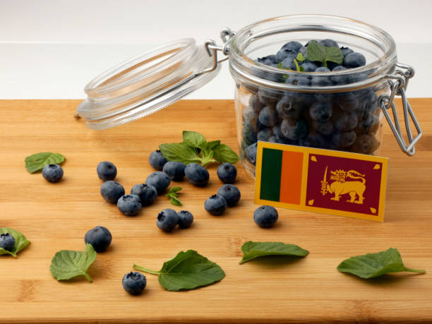 istock Sri Lankan flag on a wooden plank with blueberries isolated on white 842841122