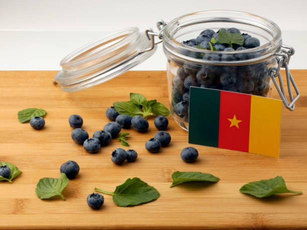 istock Cameroon flag on a wooden plank with blueberries isolated on white 842841654