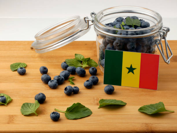 istock Senegal flag on a wooden plank with blueberries isolated on white 842841802