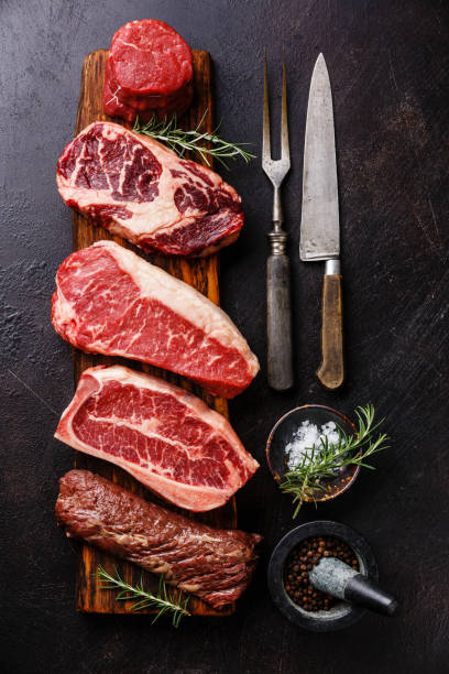 Variety of Raw Black Angus Prime meat steaks and seasoning Variety of Raw Black Angus Prime meat steaks Tenderloin fillet mignon, Rib eye, Striploin, Blade, Machete on wooden board and seasoning steak vertical beef meat stock pictures, royalty-free photos & images