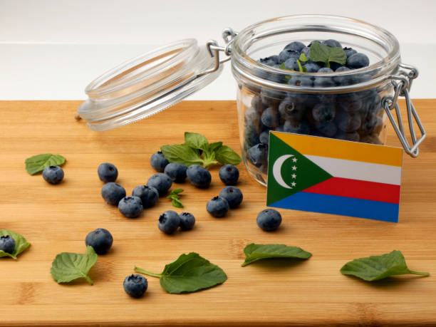 istock Comoros flag on a wooden plank with blueberries isolated on white 842844168