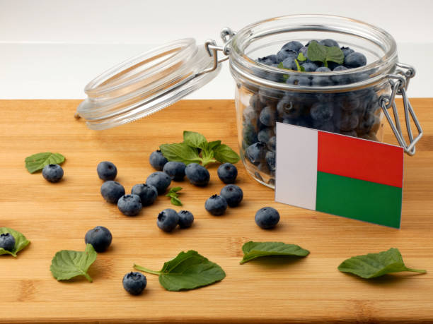 istock Madagascar flag on a wooden plank with blueberries isolated on white 842845092