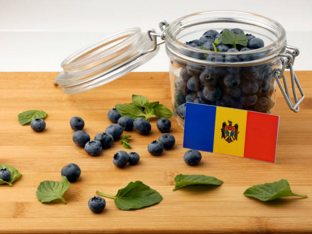 istock Moldovan flag on a wooden plank with blueberries isolated on white 842845390