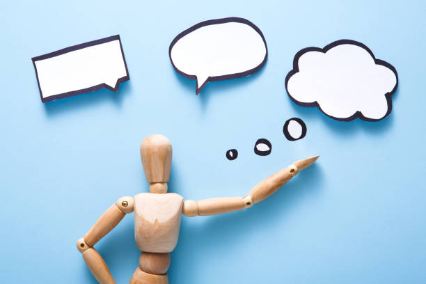 istock Wooden man figure with blank speech bubble on dark 842845404