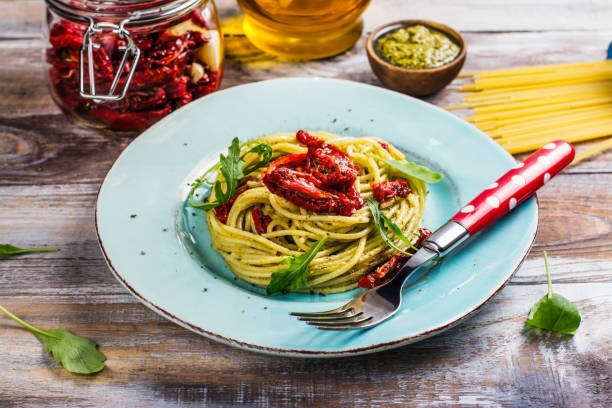 spaghetti di pasta fatti in casa con pesto e pomodori secchi - italian cuisine dry pasta directly above foto e immagini stock