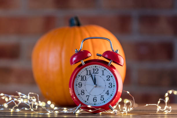 istock Autumn pumpkin with Fairy Lights and alarm clock 842848762