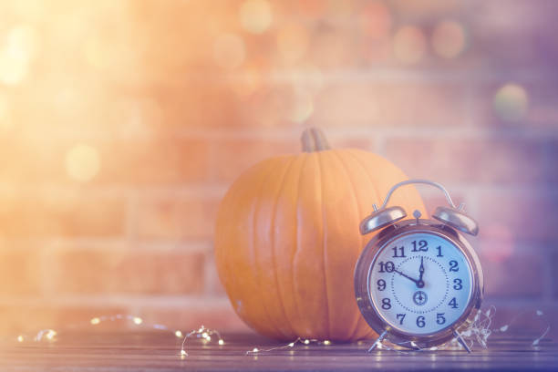 istock Autumn pumpkin with Fairy Lights and alarm clock 842848768