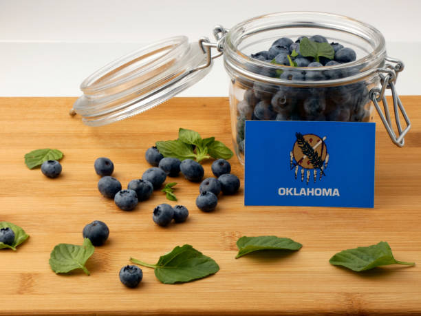 istock Oklahoma flag on a wooden plank with blueberries isolated on white 842848830