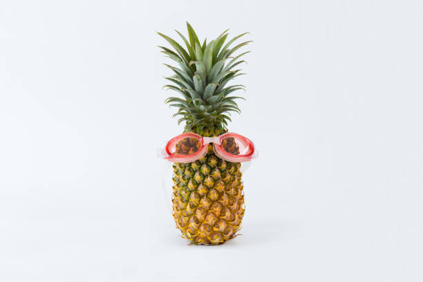 istock Ripe pineapple with swimming glasses, isolated white background,copy space. 842849676