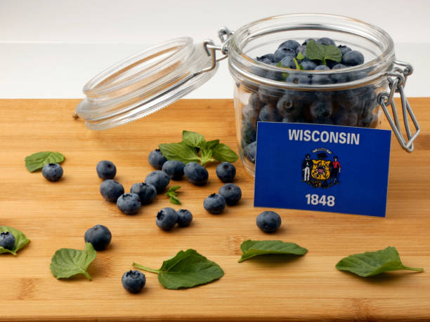 istock Wisconsin flag on a wooden plank with blueberries isolated on white 842852552