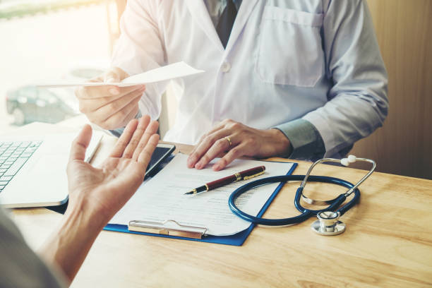 doctor o médico escritura diagnóstico y una prescripción médica a paciente femenino - receta documento fotografías e imágenes de stock